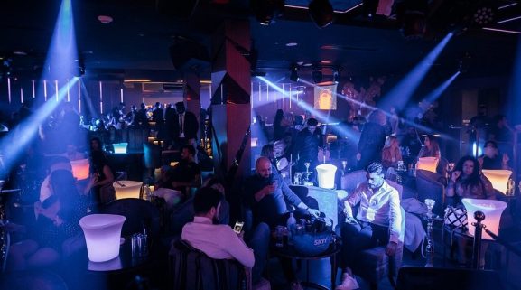 Crowds enjoying a lively night at a Khaliji nightclub in Dubai with colorful lights